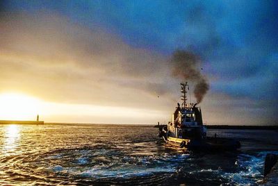 Boats in sea at sunset