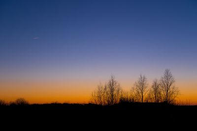 Silhouette landscape against clear sky at sunset