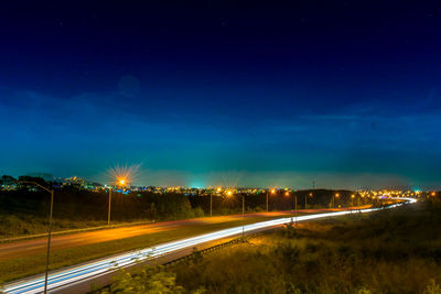 Light trails on road against sky at night