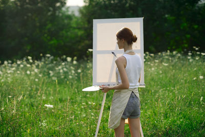 Rear view of woman standing on field