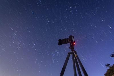 Low angle view of illuminated light against sky at night