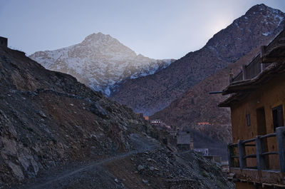 Low angle view of houses and mountains against clear sky