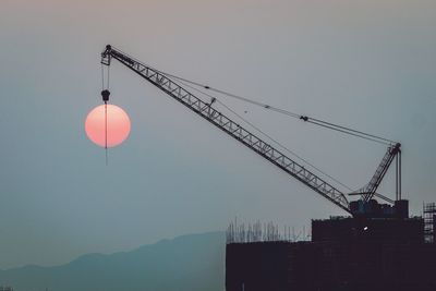 Low angle view of cranes at construction site