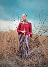 Woman standing on field against sky