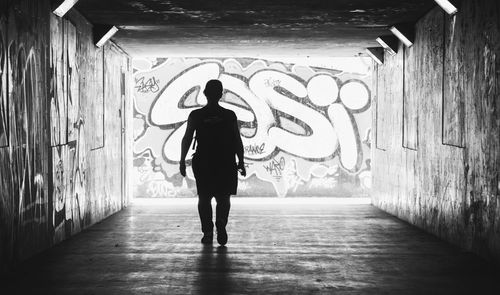 Full length rear view of man standing in corridor