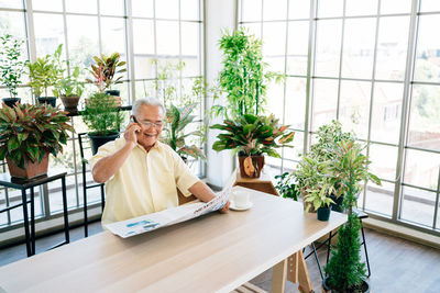 Man sitting on table by window