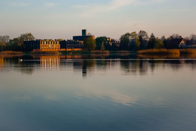 Reflection of buildings in lake against sky