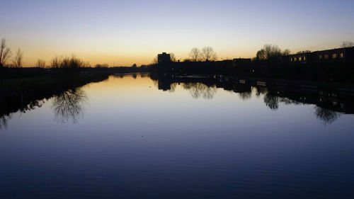Scenic view of lake against sky at sunset
