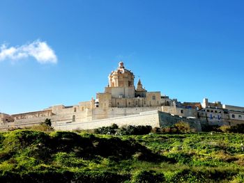 Low angle view of historic building against blue sky