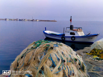 Fishing boat moored on sea against sky