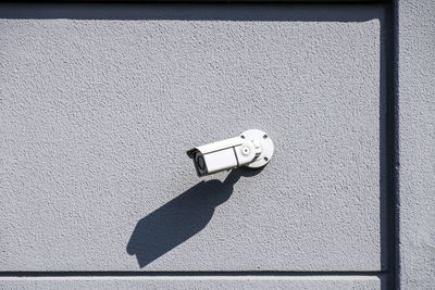 Low angle view of security camera on wall