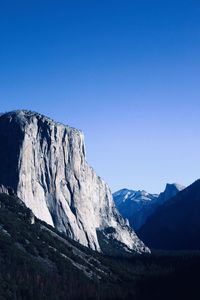 Scenic view of snowcapped mountains against clear blue sky