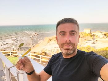 Portrait of man at beach against sky