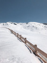 Scenic view of snow covered mountains against clear blue sky