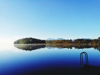 Scenic view of lake against clear blue sky