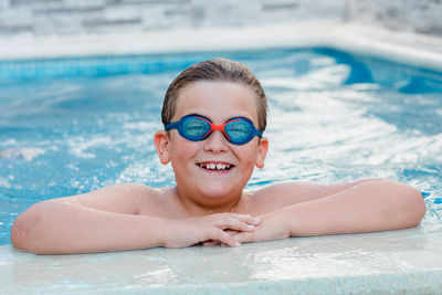 Portrait of smiling young man swimming in pool