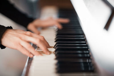 Cropped hands playing piano