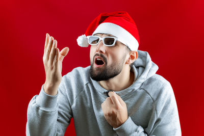 Portrait of man wearing hat against red background