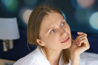 Close-up of young woman looking away indoors