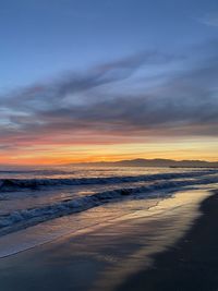 Scenic view of sea against dramatic sky during sunset