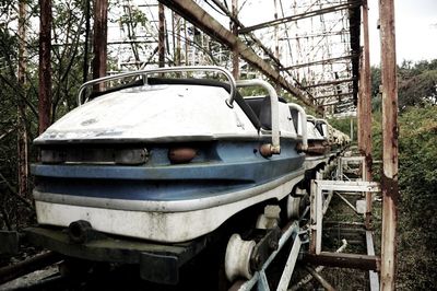 Close-up of abandoned boat against trees