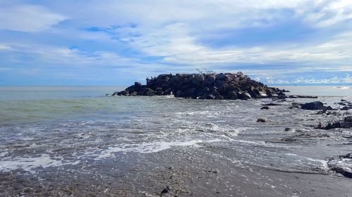 Scenic view of sea against sky and rocks 