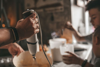 Cropped image of man holding coffee at restaurant