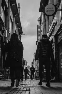 Rear view of people walking in front of building