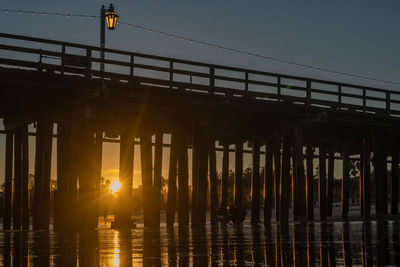 Silhouette bridge against sky during sunset