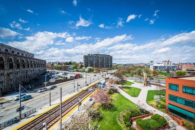 High angle view of train amidst buildings in city against sky