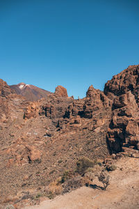 Rock formations on mountain against clear blue sky