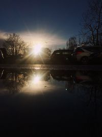 Reflection of trees on water against sky