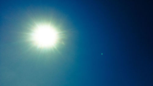 Low angle view of moon against blue sky