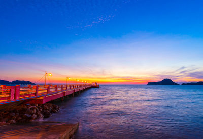 Bridge over sea against sky during sunset