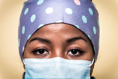 Portrait of doctor wearing mask against blue background