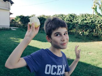 Cute boy eating fruit outdoors