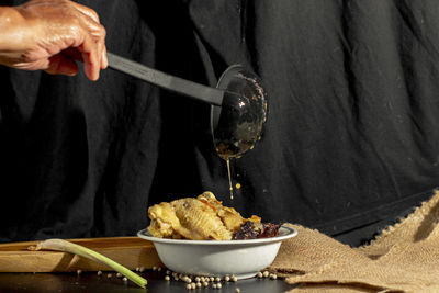 Midsection of man preparing food in bowl on table