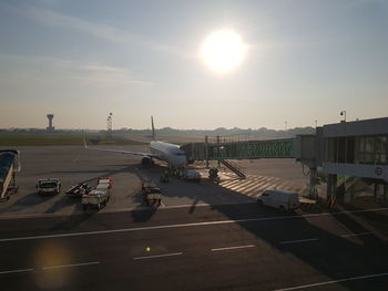 Airplane on runway against sky during sunset