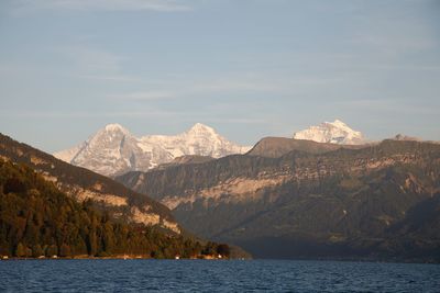 Scenic view of sea and mountains against sky