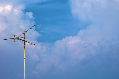Low angle view of antenna against blue sky