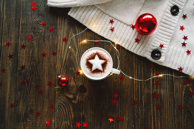 Christmas cup of coffee with sweater and christmas decorations.