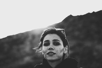 Close-up portrait of young woman against clear sky during sunset