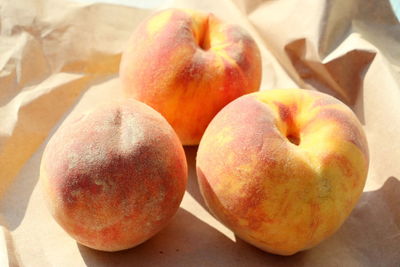 Three juicy, ripe and sweet peaches on wrapping paper. seasonal summer fruits. tasty food