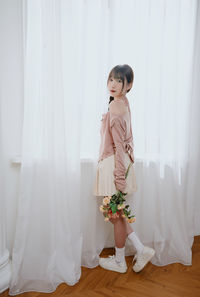 Portrait of young woman standing in wedding dress