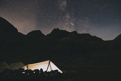 Tent at night agains the milky way over the mountains sierra de gredos