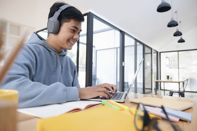 Young collage student using computer and mobile device studying