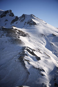 Scenic view of snowcapped mountains against clear sky