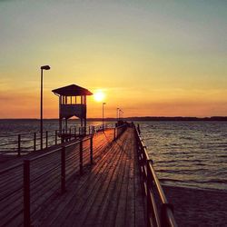 Pier on sea during sunset