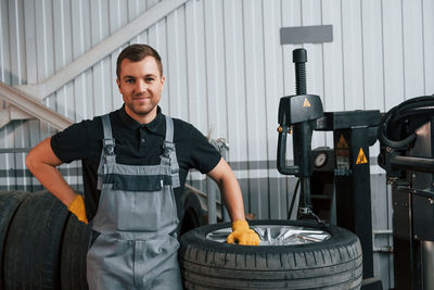 Portrait of young man standing in factory