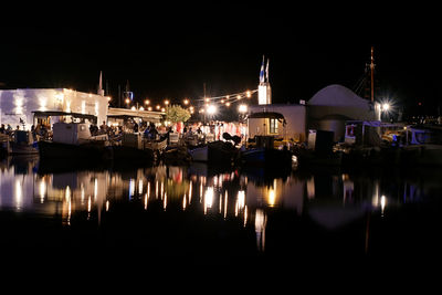 Reflection of buildings in lake at night